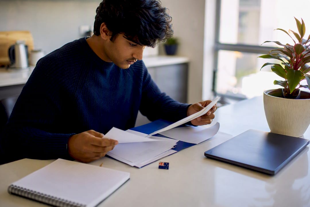 Student arranging documents at study desk
